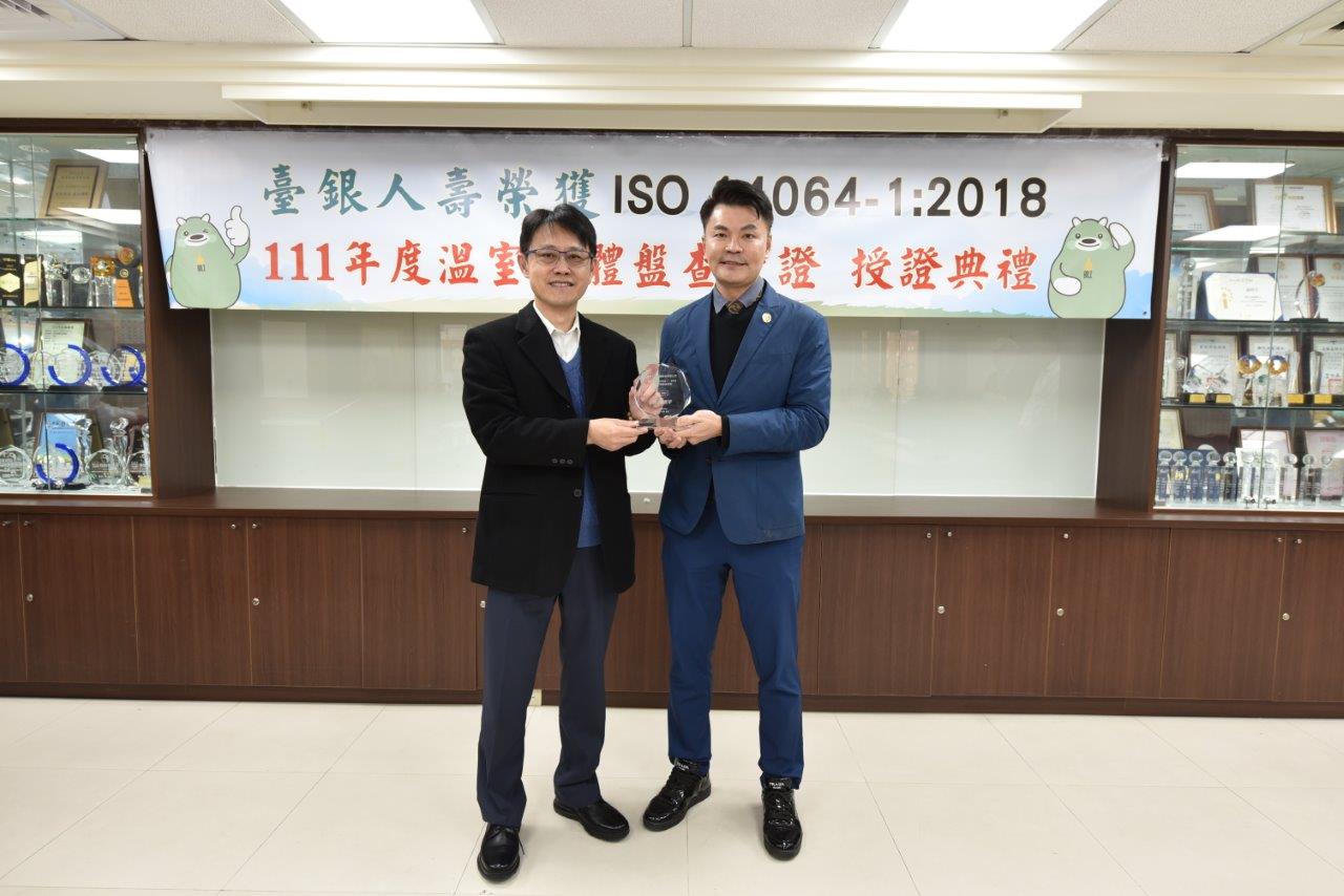在臺銀人壽 ISO 14064-1:2018 授證儀式上，由領導力企管總經理兼首席顧問王聖源（右）敬贈臺銀人壽董事長張志宏（左）獎座。